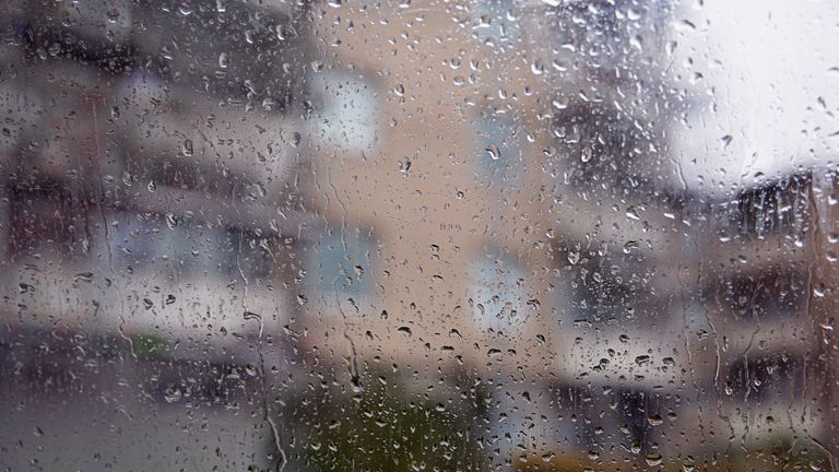 Rett hus syns genom ett fönster täckt av regndroppar