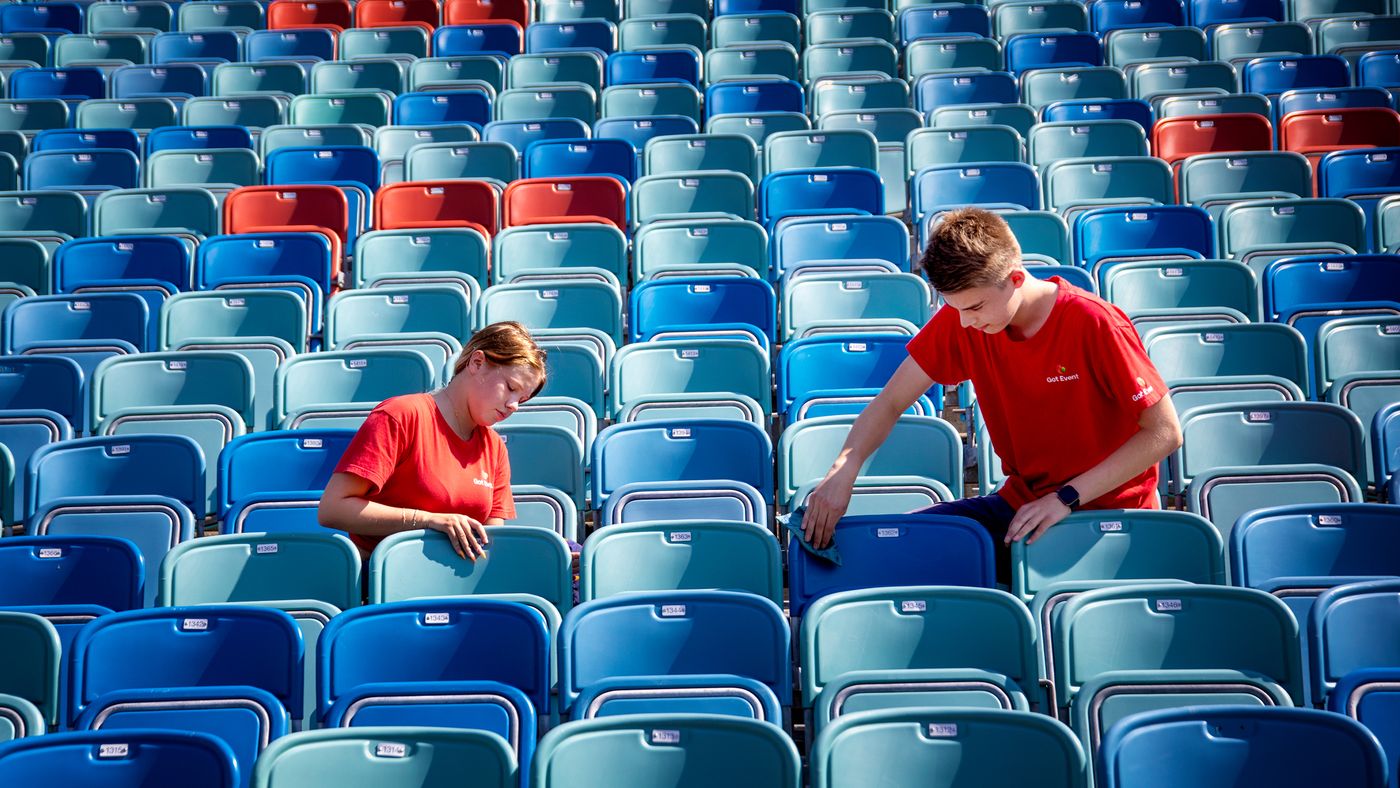 Två ungdomar sommarjobbar på en arena.